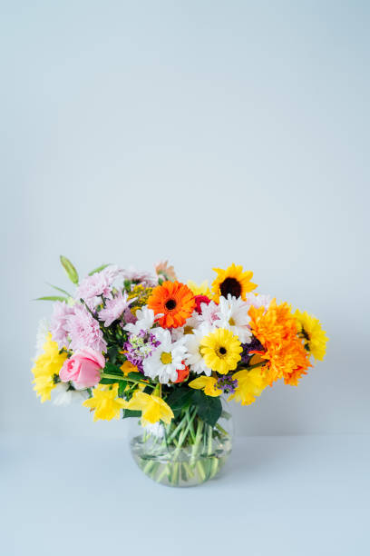 istock Round Vase with huge multicolor various mixed flower bouquet on the light gray, white background. Giving flowers. Mother's day, women day, valentine's day, birthday gift. Vertical card. Copy space 1481204701