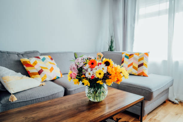 ваза с огромным разноцветным букетом различных цветов на журналь�ном столике с размытым фоном современной уютной светлой гостиной с серым � - daffodil flower yellow vase стоковые фото и изображения