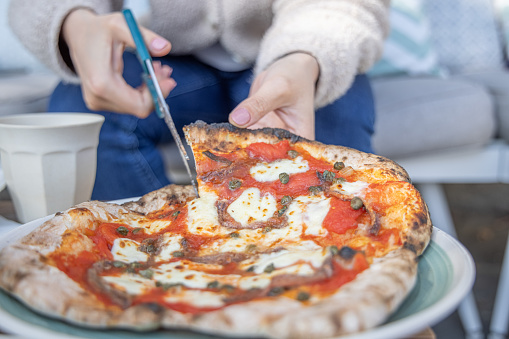 Vegan pizza being cut with scissors