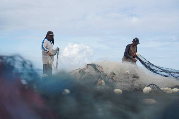 Fishermen pull their net on a beach in Banda Aceh on October 29, 2022