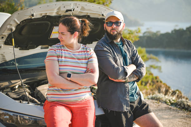 casal viajante discutindo perto de um carro quebrado - stranded travel people traveling disappointment - fotografias e filmes do acervo