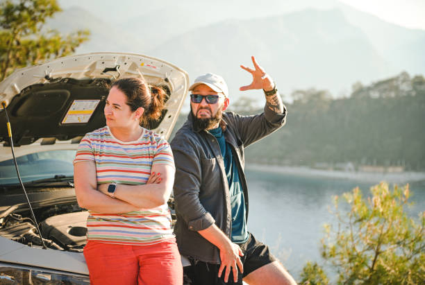 casal viajante discutindo perto de um carro quebrado - stranded travel people traveling disappointment - fotografias e filmes do acervo