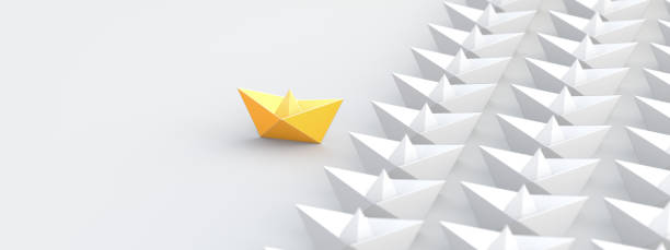 Leadership concept, yellow leader boat, standing out from the crowd of white boats stock photo