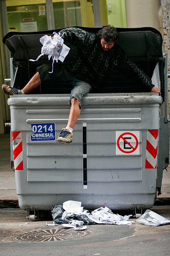 Porto Alegre, Rio Grande do Sul, Brazil - Jul 15th, 2012: Waste picker man collecting trash from an automated container