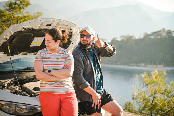 casal viajante discutindo perto de um carro quebrado - stranded travel people traveling disappointment - fotografias e filmes do acervo