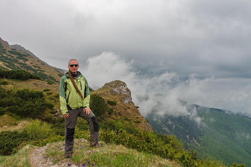 Hiker with dreadlocks on mountain pass Bublen, Mala Fatra, Slovakia, in spring cloudy day