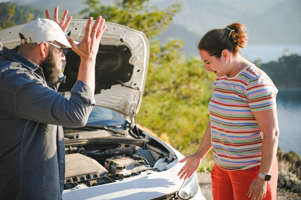 casal viajante discutindo perto de um carro quebrado - stranded travel people traveling disappointment - fotografias e filmes do acervo