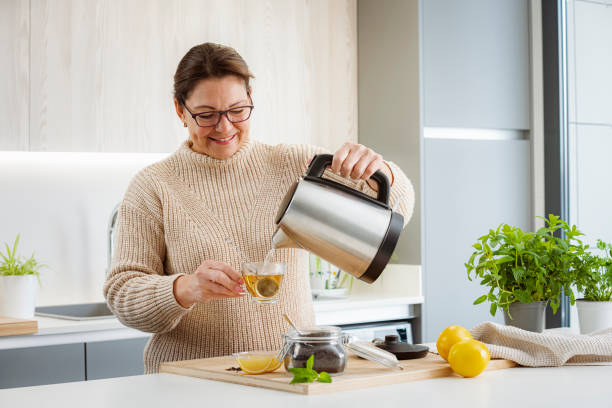 istock Happy woman preparing hot tea in kitchen 1481221337