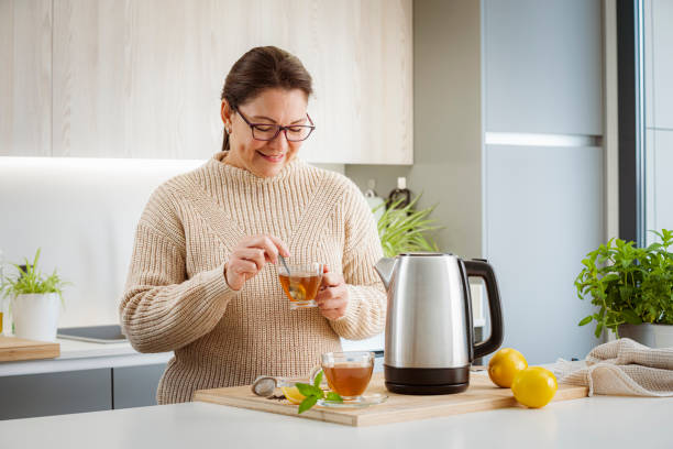 istock Woman preparing hot tea in kitchen 1481221369