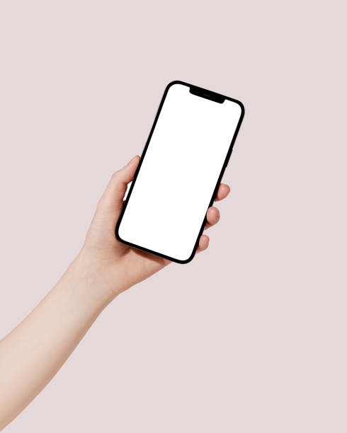 istock Female hand holding cell phone with blank screen on pink background. Mockup 1481221466