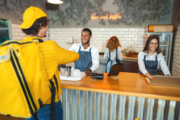 istock White delivery man shaking hands with employee while picking up customers order at the bar 1481221727