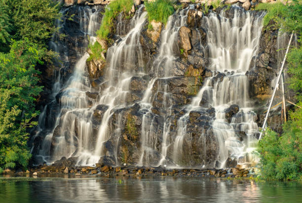 istock Artificial waterfall above river in summer day. Water cascade flowing on stones. 1481222693