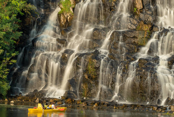 istock Artificial waterfall above river in summer day. Water cascade flowing on stones. 1481222696