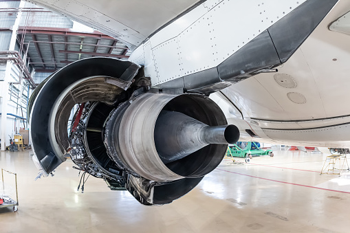 Rear view of the open high-bypass turbofan airplane engine of a passenger jet plane in a hangar