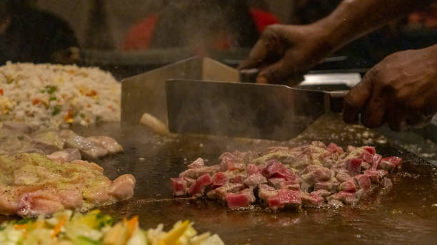 istock Teppanyaki chef entertaining with spatulas 1481229629