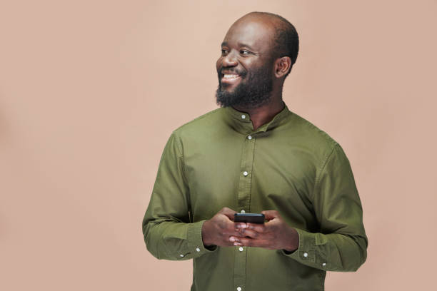 hombre afroamericano feliz usando un teléfono inteligente - nativo digital fotografías e imágenes de stock