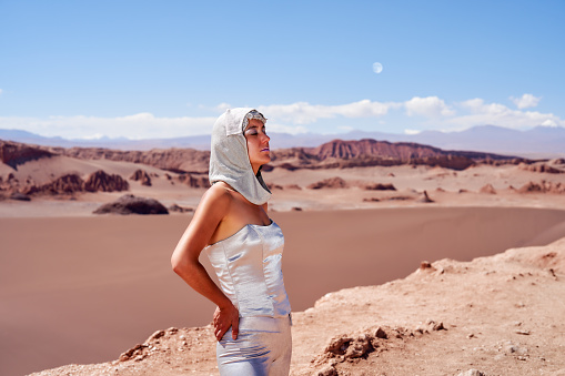waist up portrait latina woman with silver clothes and bandana or head cape in the desert of Valley of the Moon in the Atacama desert of San Pedro de Atacama