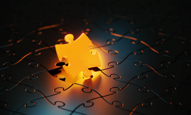 istock Orange Jigsaw Puzzle Piece Glowing On Black Background 1481232449