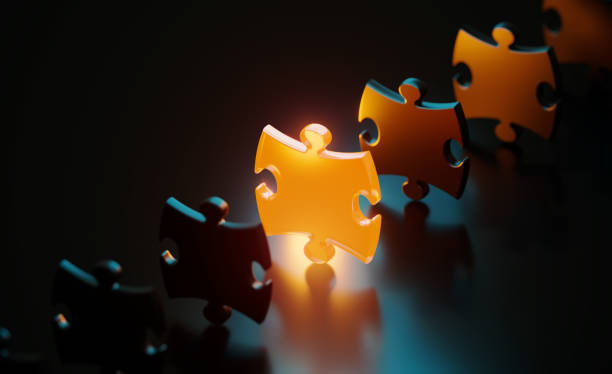 istock Orange Jigsaw Puzzle Piece Glowing Amid Black Jigsaw Pieces On Black Background 1481232514
