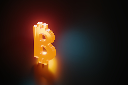 Orange Bitcoin symbol glowing on black background. Horizontal composition with copy space.