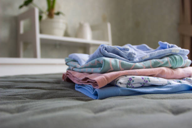 istock Clean colored clothes on the bed in a bedroom, blured background 1481232622