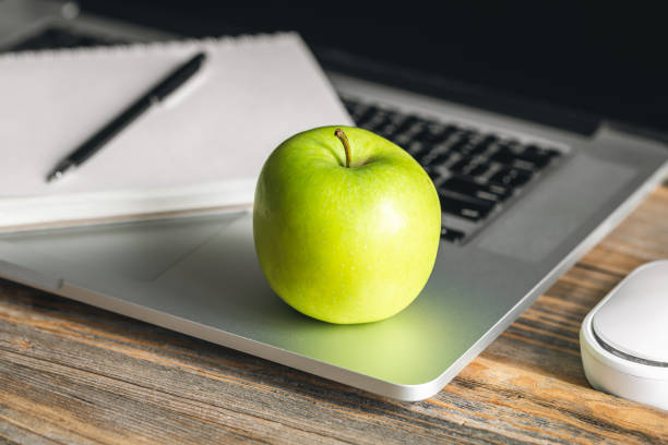 istock Apple near laptop at workplace, healthy snack. 1481238385