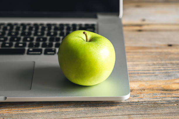 istock Apple near laptop at workplace, healthy snack. 1481238388