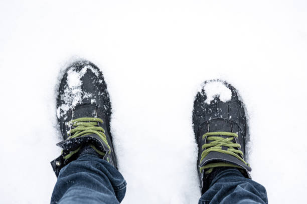 istock Men's feet in boots in deep snow, top view. 1481238438