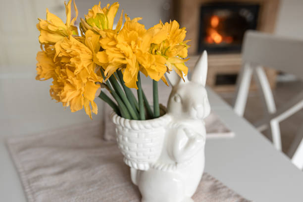 Bouquet of daffodils in a vase in the shape of a hare, Easter composition.