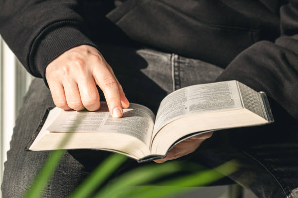 istock Open book Bible in male hands, close-up. 1481239535