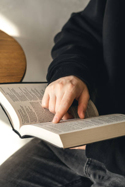 istock Open book Bible in male hands, close-up. 1481239536