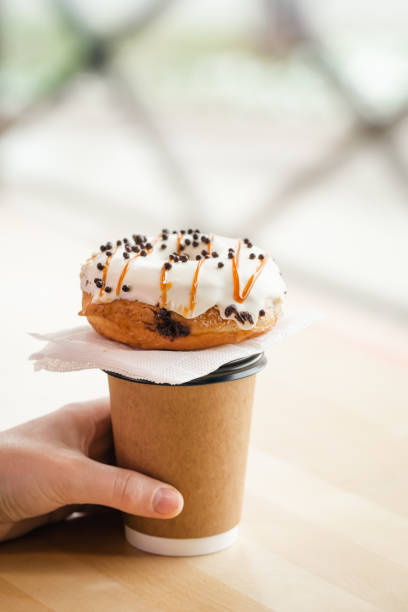 istock Appetizing donut and coffee in male hands, close-up. 1481239732