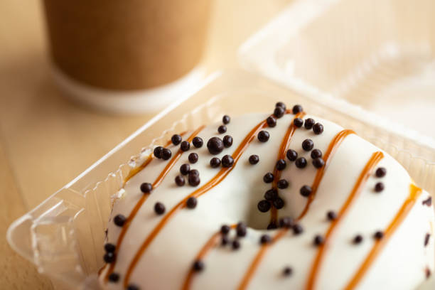 istock Appetizing caramel donut in a plastic tray, close-up. 1481239743
