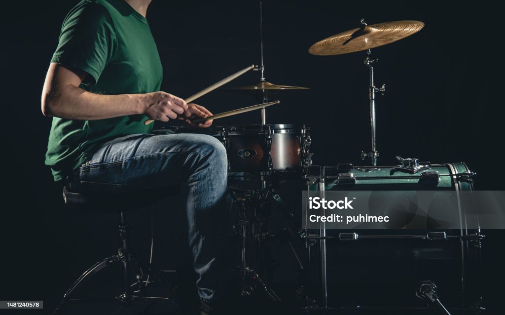 A man plays a drum kit on a black background. - Royaltyfri 30-34 år Bildbanksbilder A man plays a drum kit on a black background. - Royaltyfri 30-34 år Bildbanksbilder