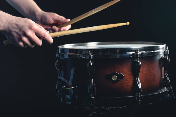 istock Drummer using drum sticks hitting snare drum with splashing water. 1481240983