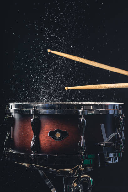 istock Drummer using drum sticks hitting snare drum with splashing water. 1481240987
