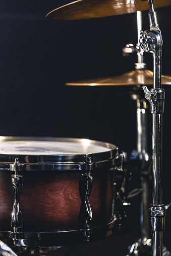 Snare drum on a blurred dark background, part of a drum kit, music concert cncept.