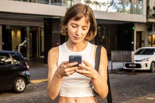 istock Young woman using phone outdoors 1481241763
