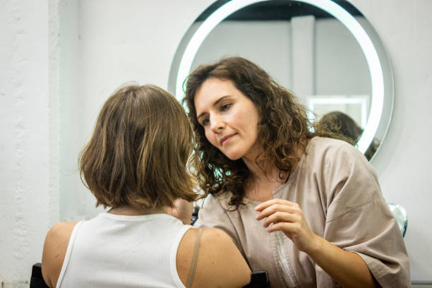 istock Mid adult woman doing makeup on a client at beauty studio 1481242019