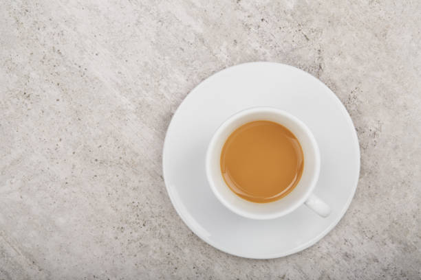 White cup of coffee from above on concrete cafe table