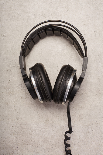 Old style vintage headphones flat lay on concrete background
