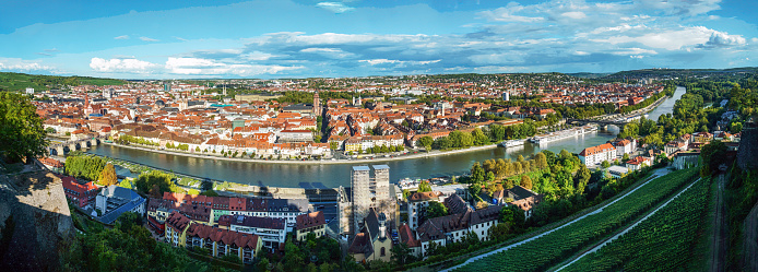 Fairy tale town:  Wurzburg in Bavaria. Panorama from hill of Marienberg fortress :  at left direction - pedestrian  old  Main bridge on Main \nriver)  At bottom on hill slope - vineyard .
