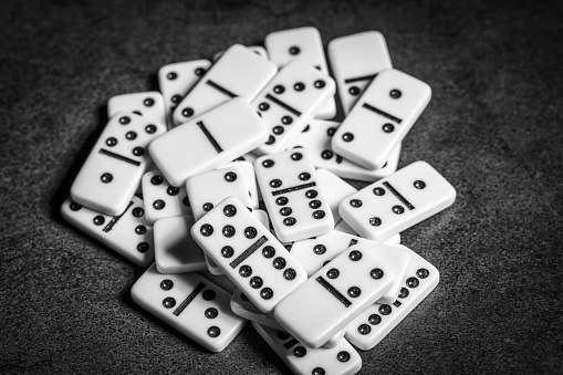 a group of white domino tiles on a dark background close-up , black and white photo