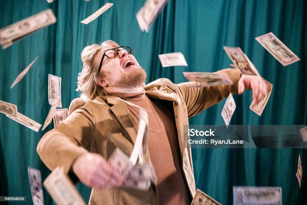 Retro Styled Man Celebrates in Falling Money Vintage looking Caucasian man with late 1970's or early 1980's fashion styling. He smiles with joy as cash falls down in the air around him.  Turtleneck with a blazer and gold chain. Currency Stock Photo