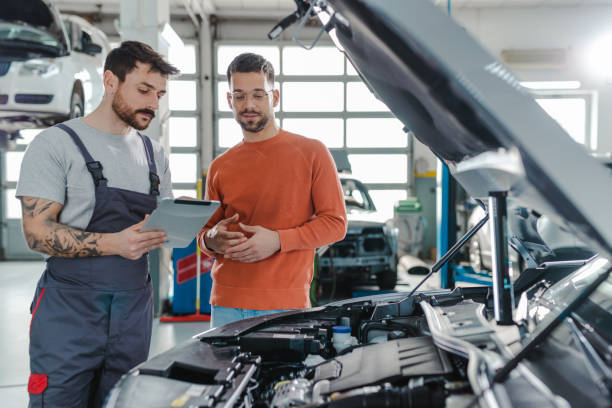 istock Customer and automotive technician talking in a workshop 1481250493