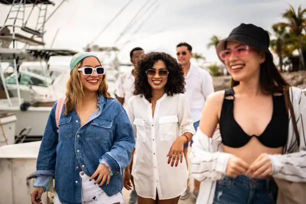 Photo of Group of friends arriving to the harbor to enter a yacht