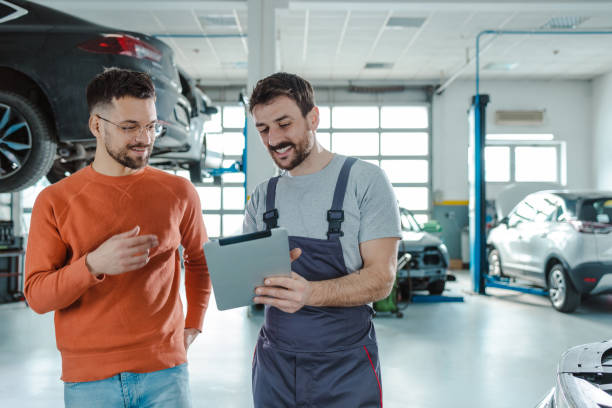 istock Happy customer and auto mechanic using digital tablet in a workshop 1481251253