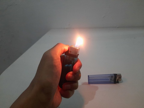 someone's hand holding a lighter