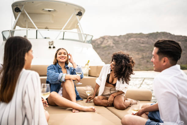 Happy friends talking during a yacht trip Happy friends talking during a yacht trip yacht stock pictures, royalty-free photos & images