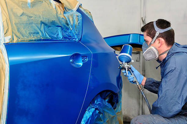 pracownik malowanie samochodu. - auto repair shop adult auto mechanic blue zdjęcia i obrazy z banku zdjęć